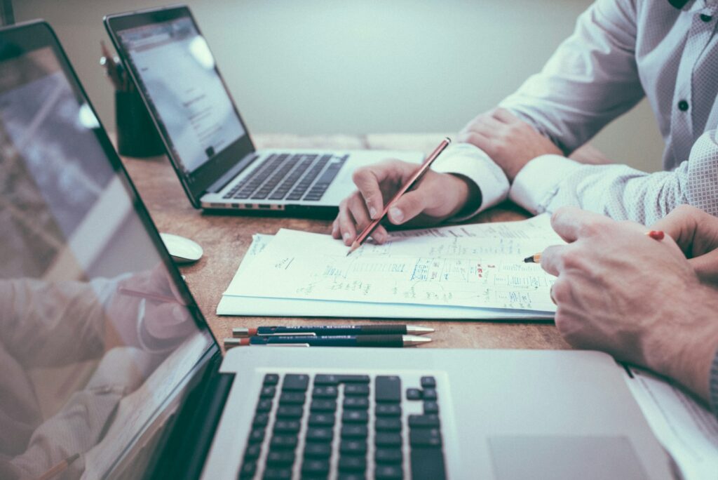 person holding pencil near laptop computer- Free Company Email Accounts