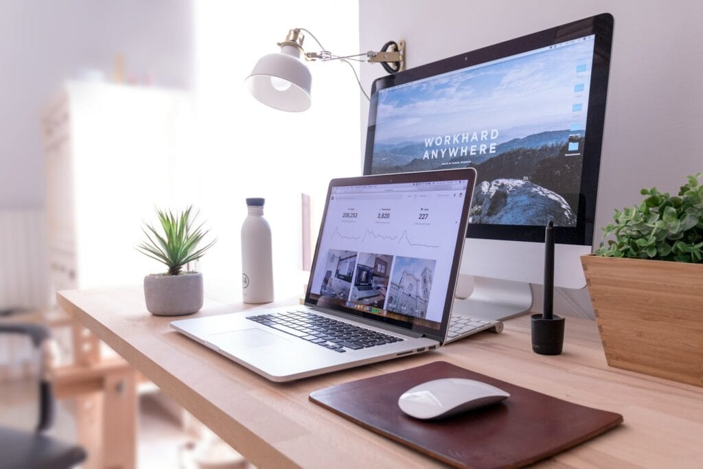 MacBook Pro on table beside white iMac and Magic Mouse- email mailing