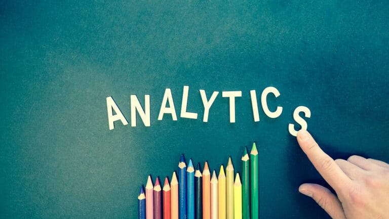 Colored pencils and letters spelling 'ANALYTICS' on a textured background with a hand.Email Marketing Trends 2025